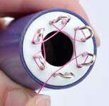 Wire being wrapped around the spokes of the knitter